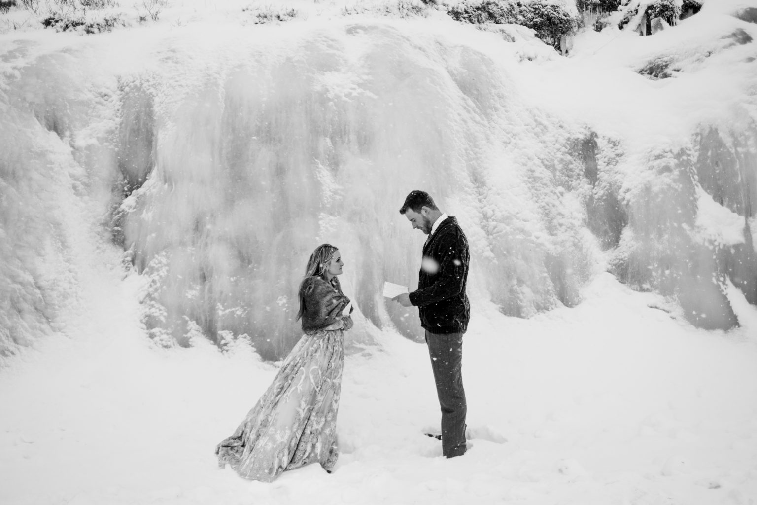 The couple tiny against a huge ice wall, Lofoten, Norway