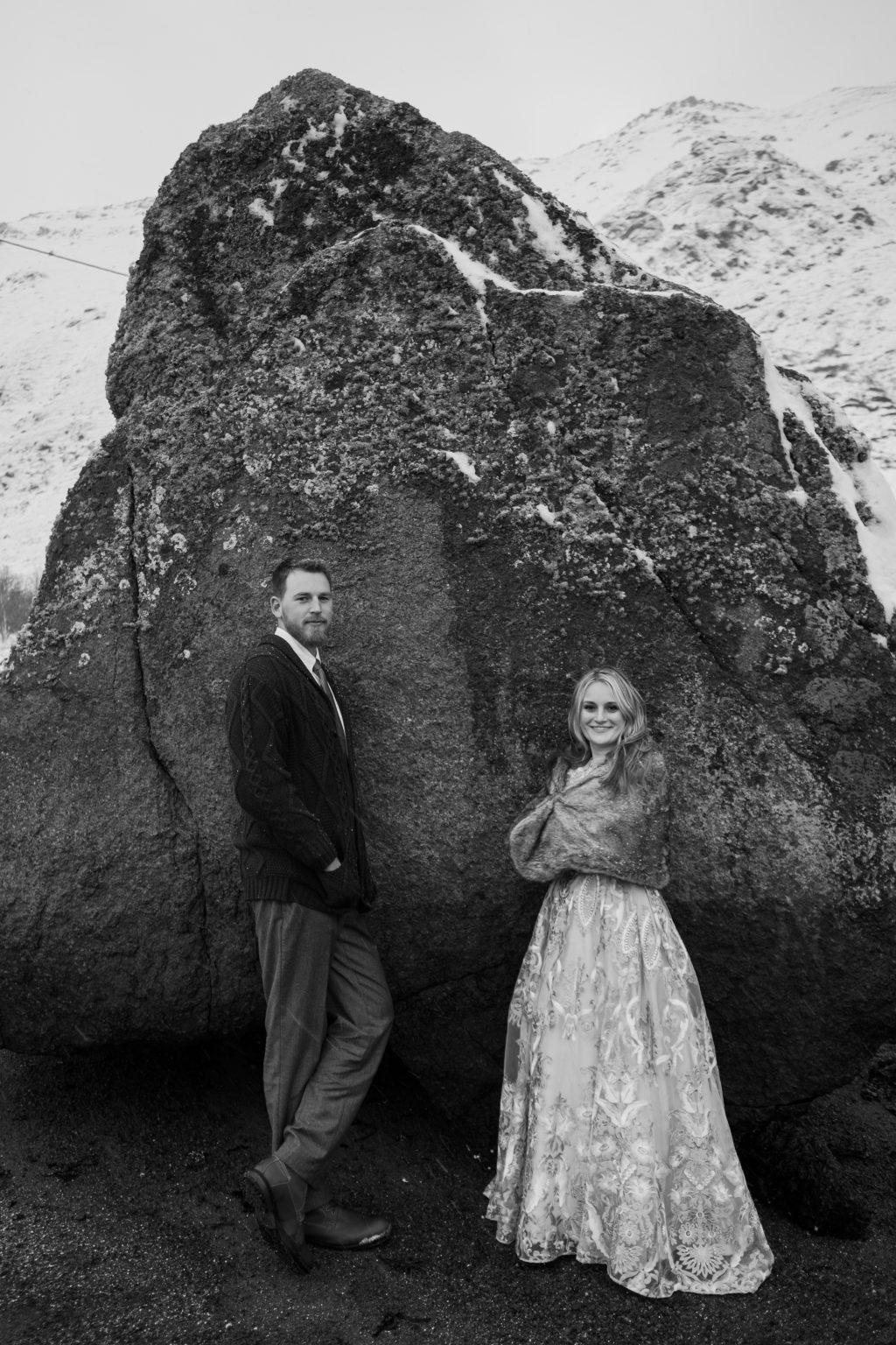 The couple below a great boulder in the snow, Lofoten