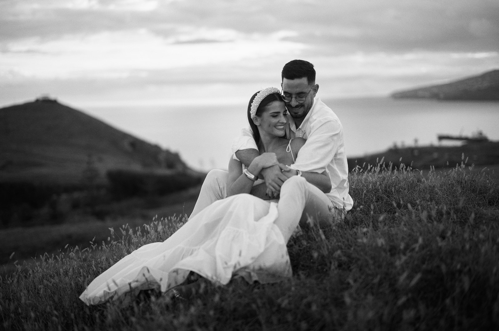 Bride and groom embrace at Ponta de São Lourenço at sunset in black and white