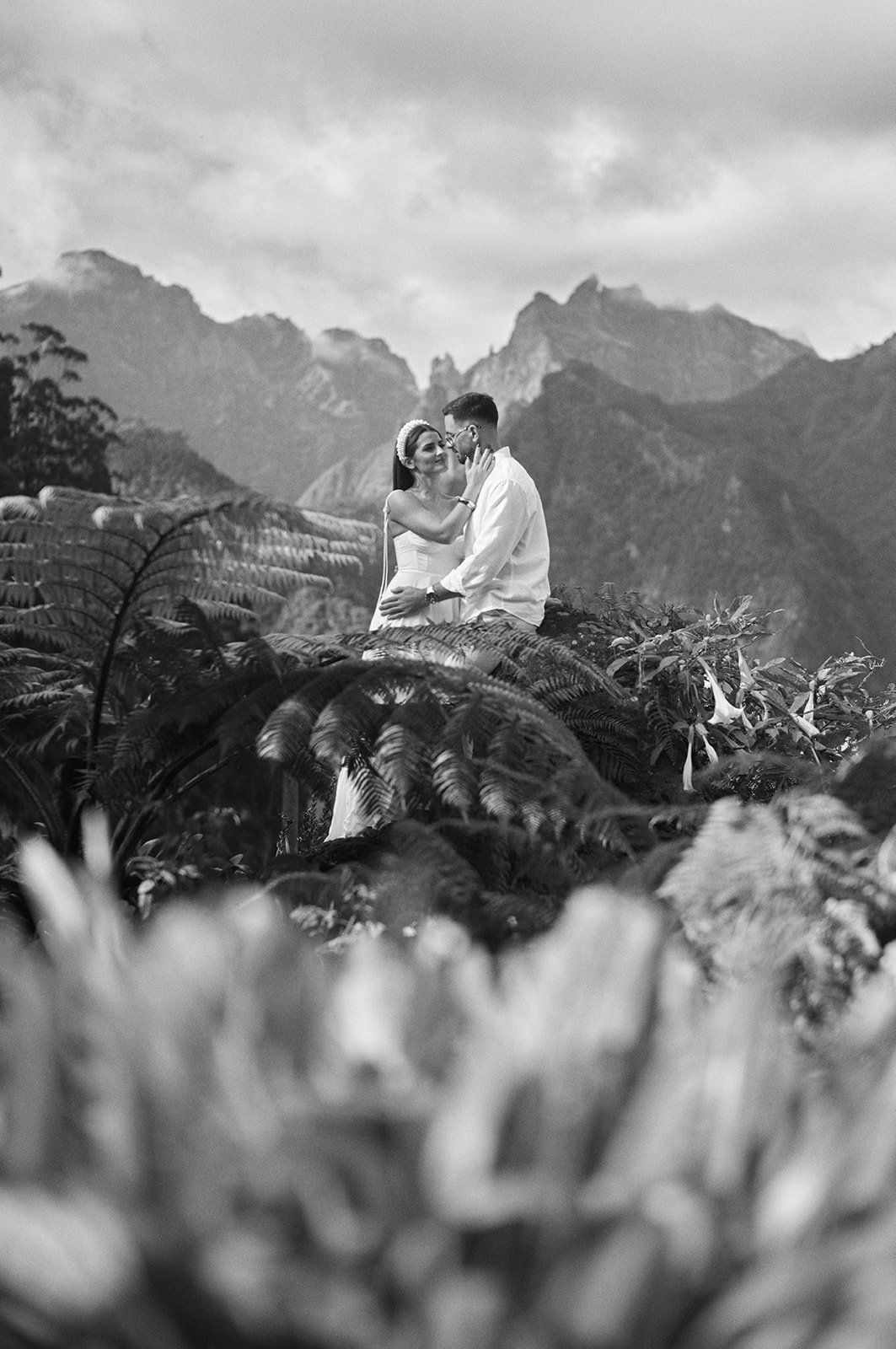 Bride and groom above a Madeira hillside in black and white