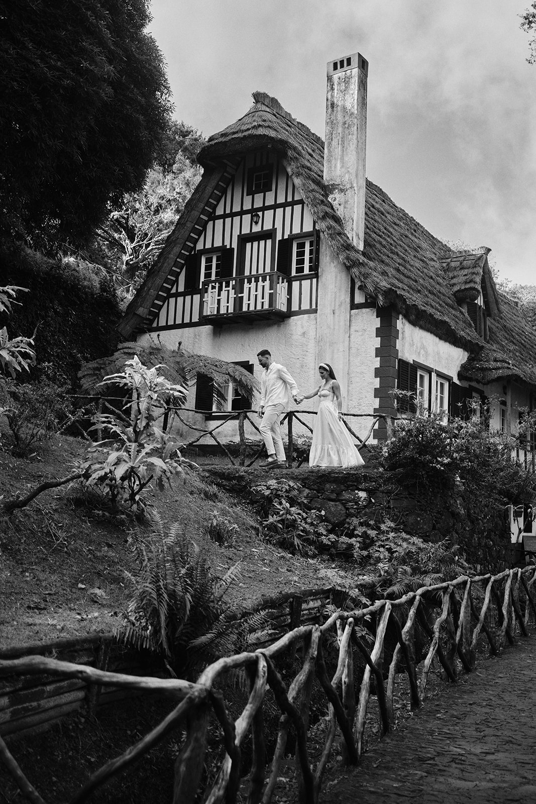 Bride and groom by a thatched Queimadas house in Madeira