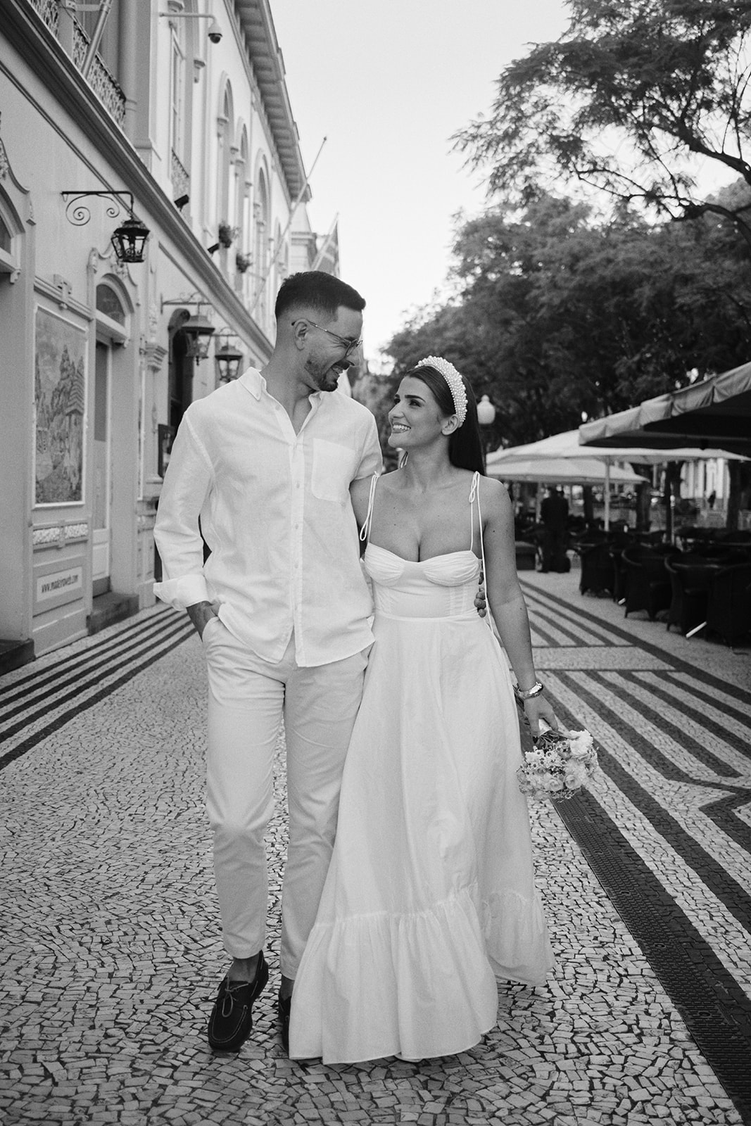 Bride and groom walking a Funchal street in black and white