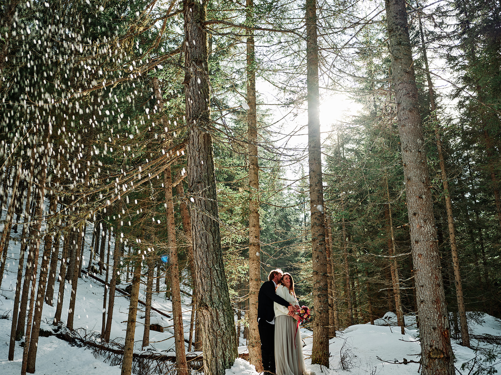 Elopement couple in the sunlit winter forest at Passo Gardena, Val Gardena Dolomites - Nordica Photography