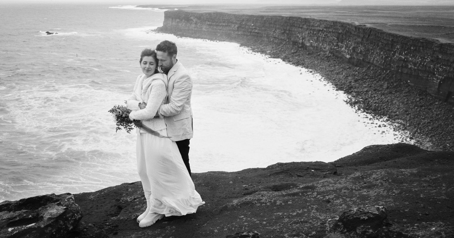 Couple embracing on the sea cliffs of Reykjanes, black and white