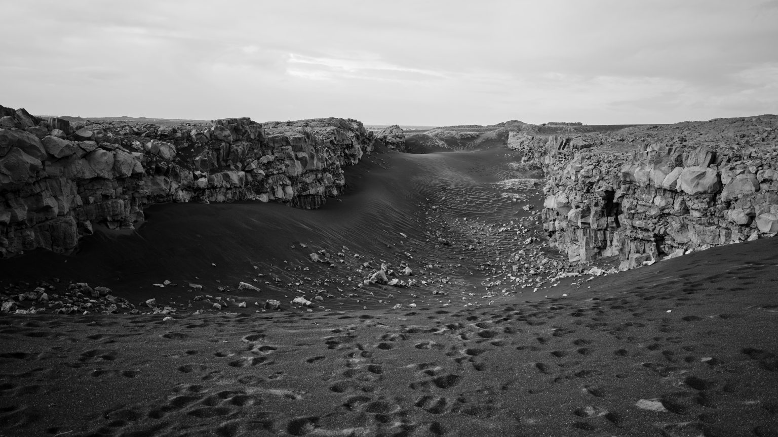 Black sand rift on Reykjanes, a tiny figure below the walls