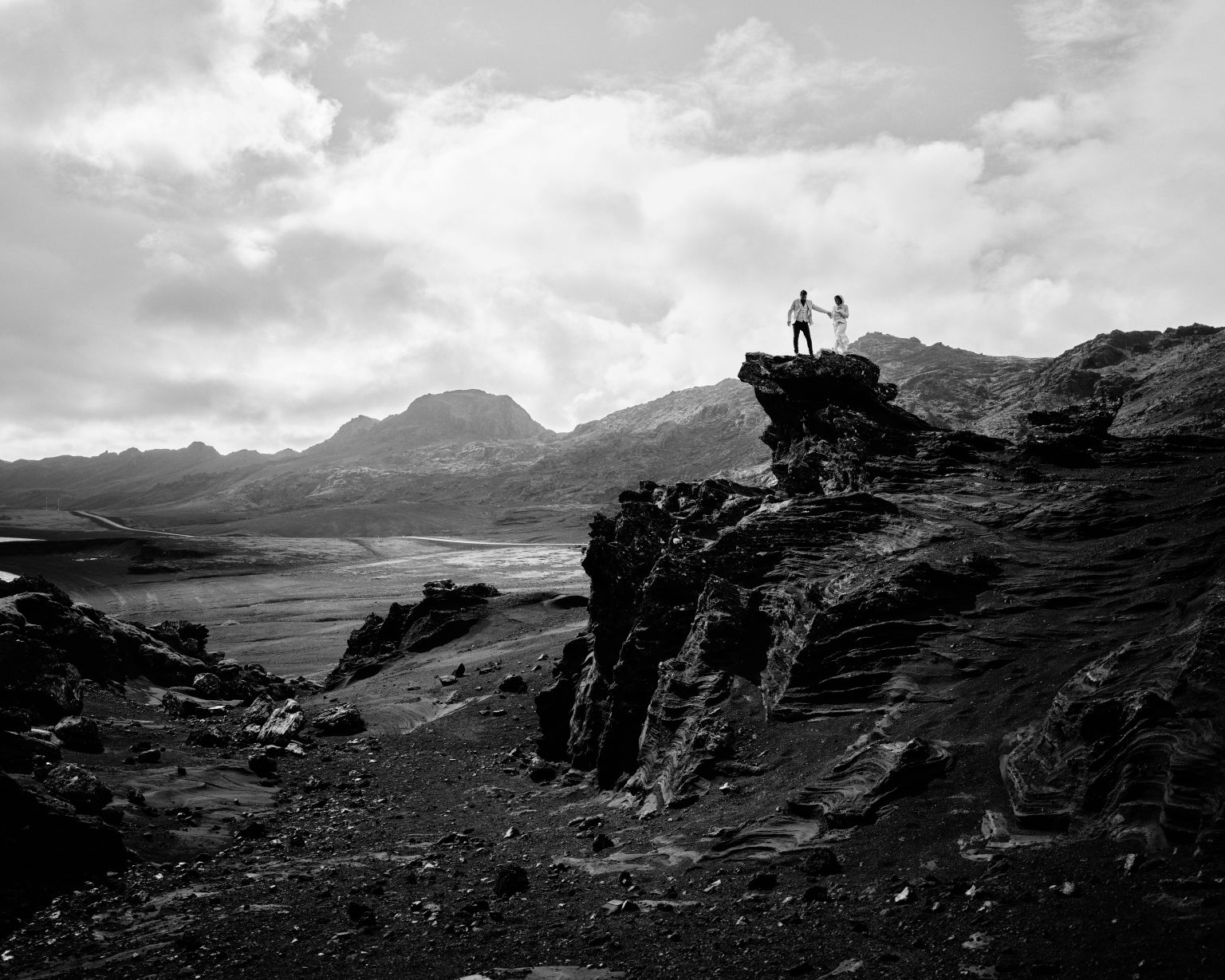 Andreea and Matthias small on a rocky ridge, Krýsuvík
