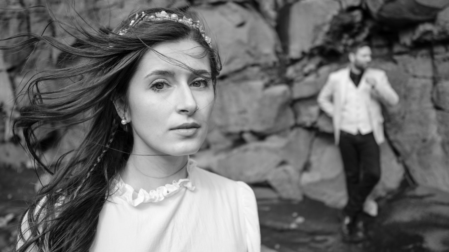 Bride portrait with the groom behind on the black sand, Reykjanes