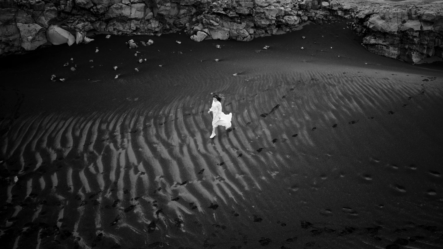 Bride alone on the black sand ripples of Reykjanes