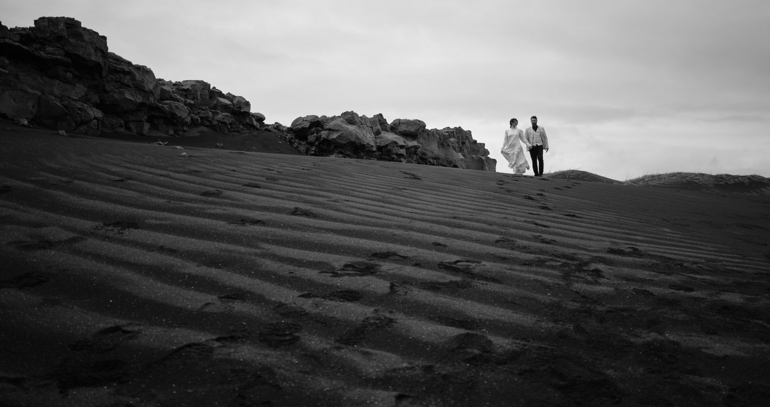 Andreea and Matthias small on the black sand plain, Reykjanes
