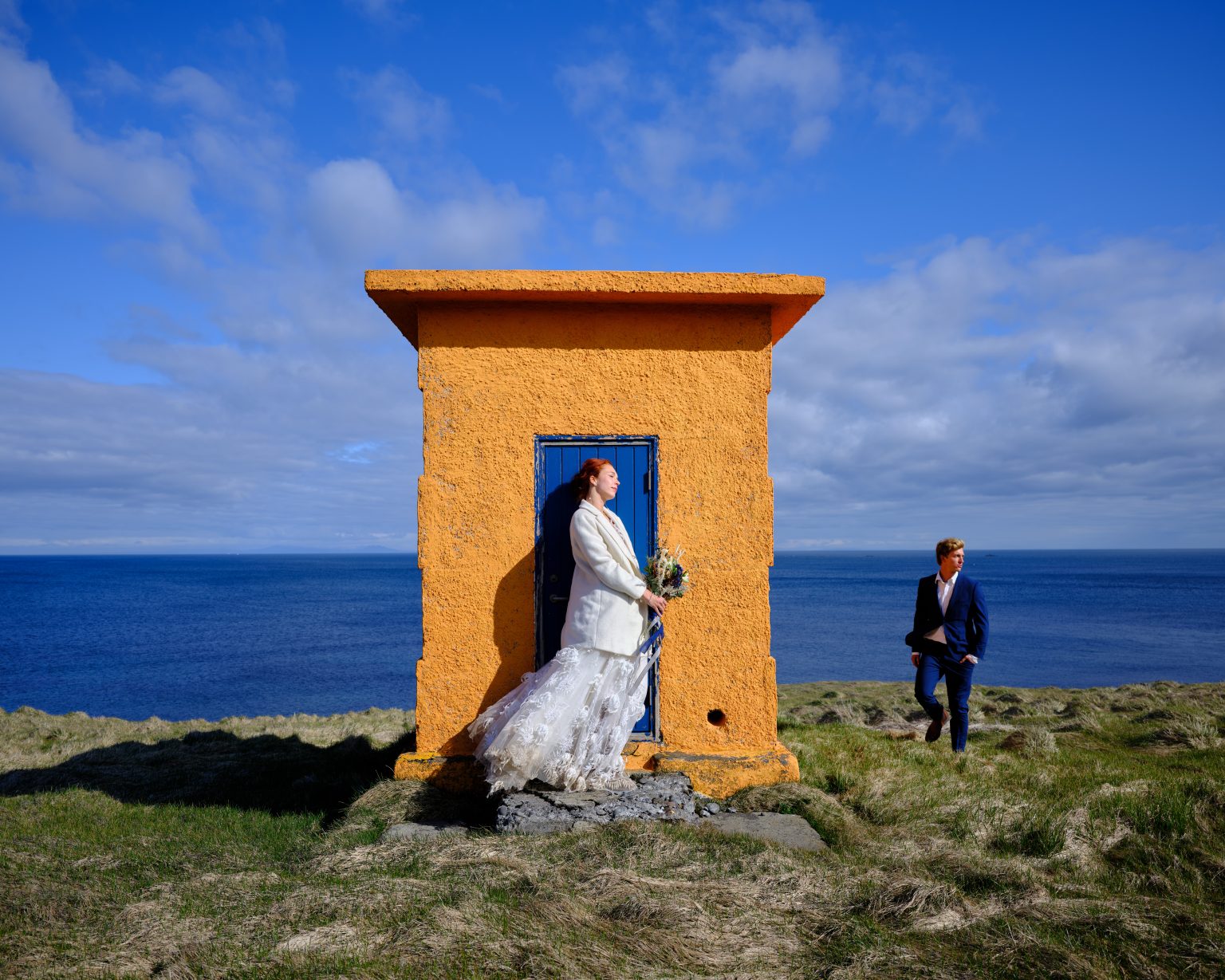 Bride in the doorway of the orange Svörtuloft lighthouse