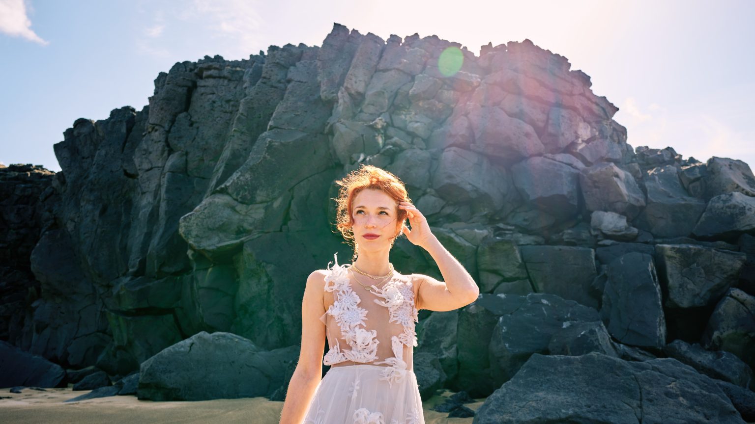 Bride in a cove of dark basalt cliffs, Snæfellsnes