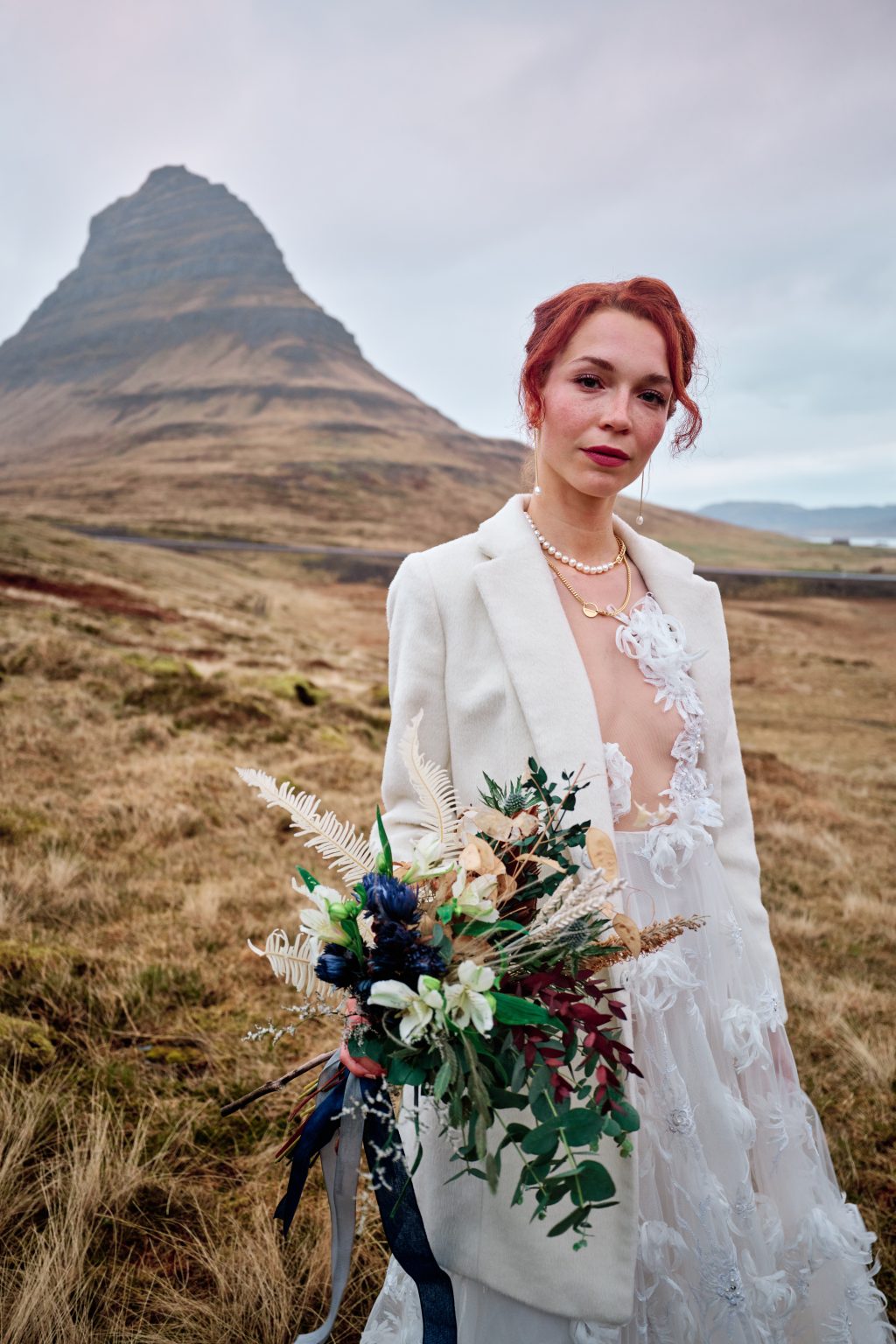 Bride with a wild bouquet in front of Kirkjufell, Iceland elopement