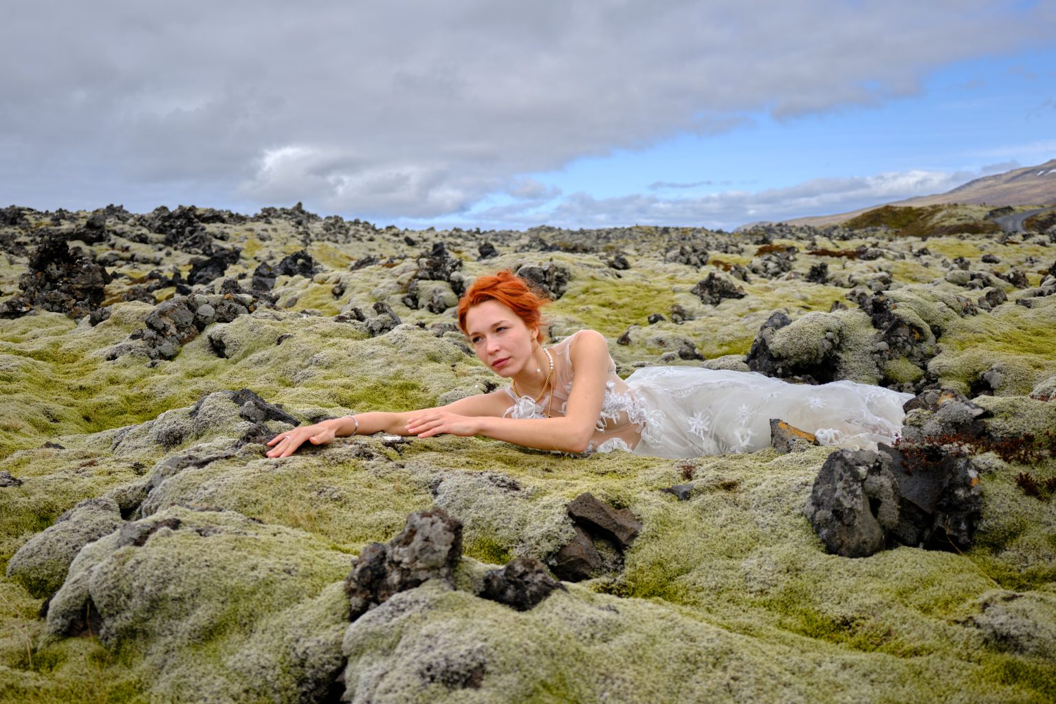 Anna lying in the green mossy lava, Snæfellsnes