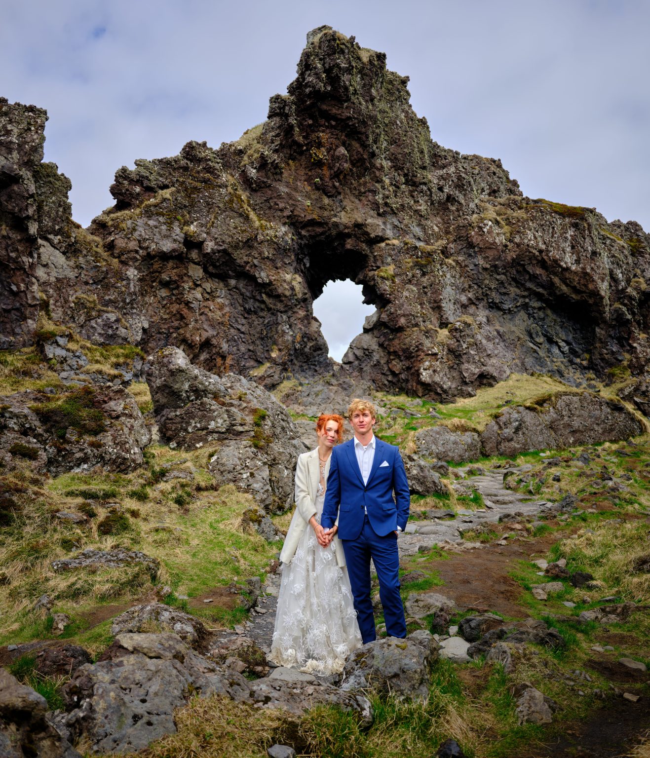 Anna and Niklas beneath the Gatklettur arch at Arnarstapi
