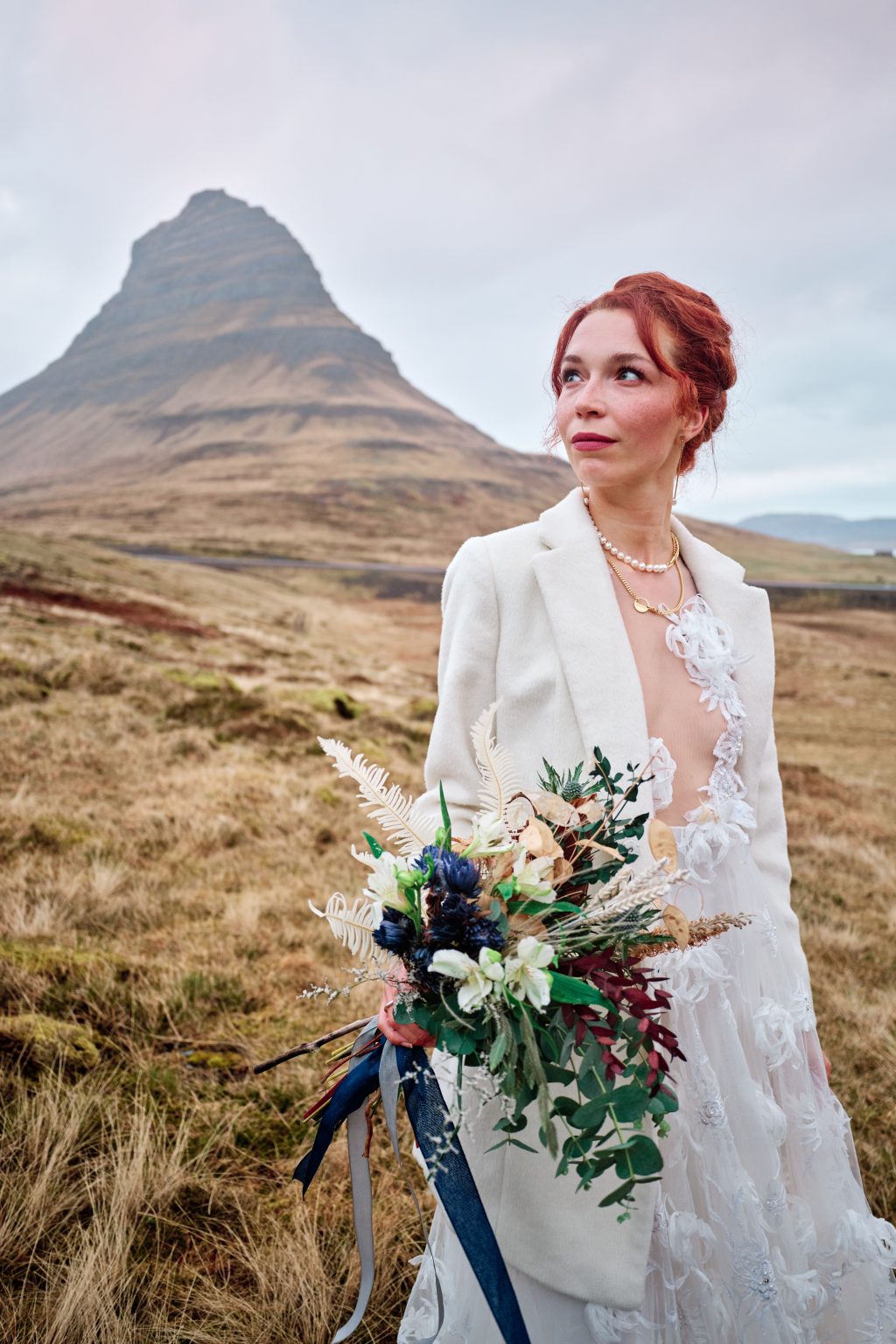 Anna in her white suit and dress below Kirkjufell mountain