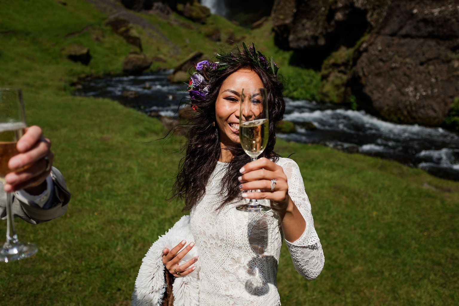 Couple toasting champagne after their vows below Kvernufoss, South Iceland elopement