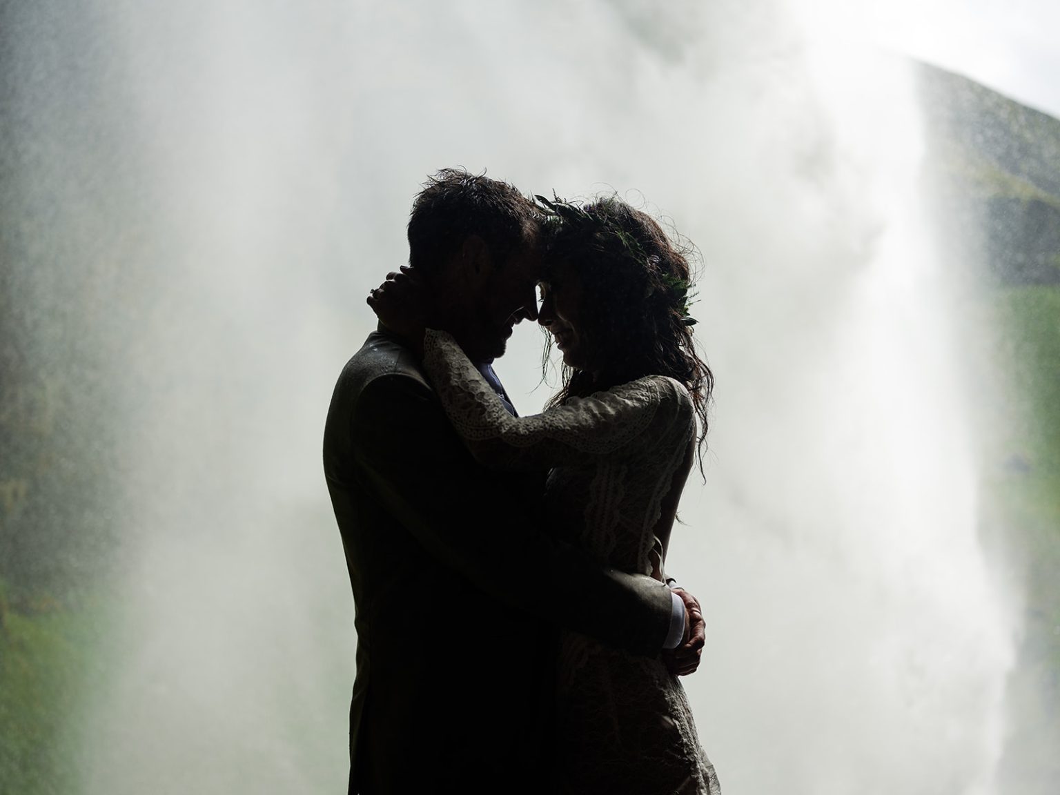 Couple embracing behind Kvernufoss, South Iceland elopement