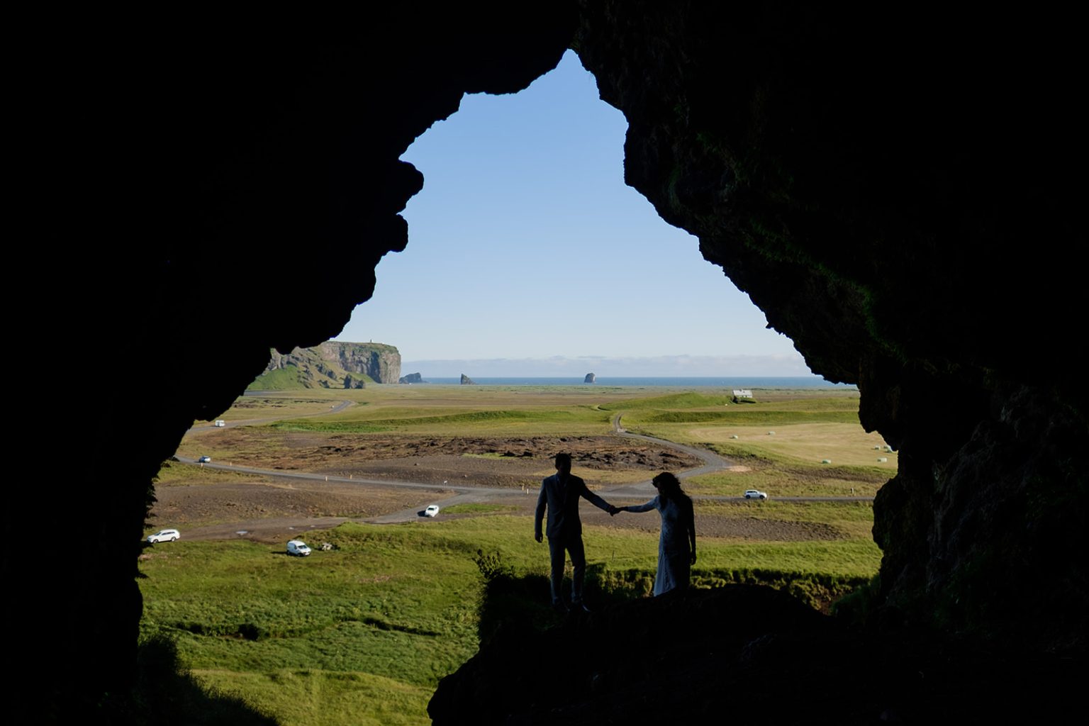 Bride and groom in silhouette inside the great sea arch at Dyrholaey, South Iceland elopement