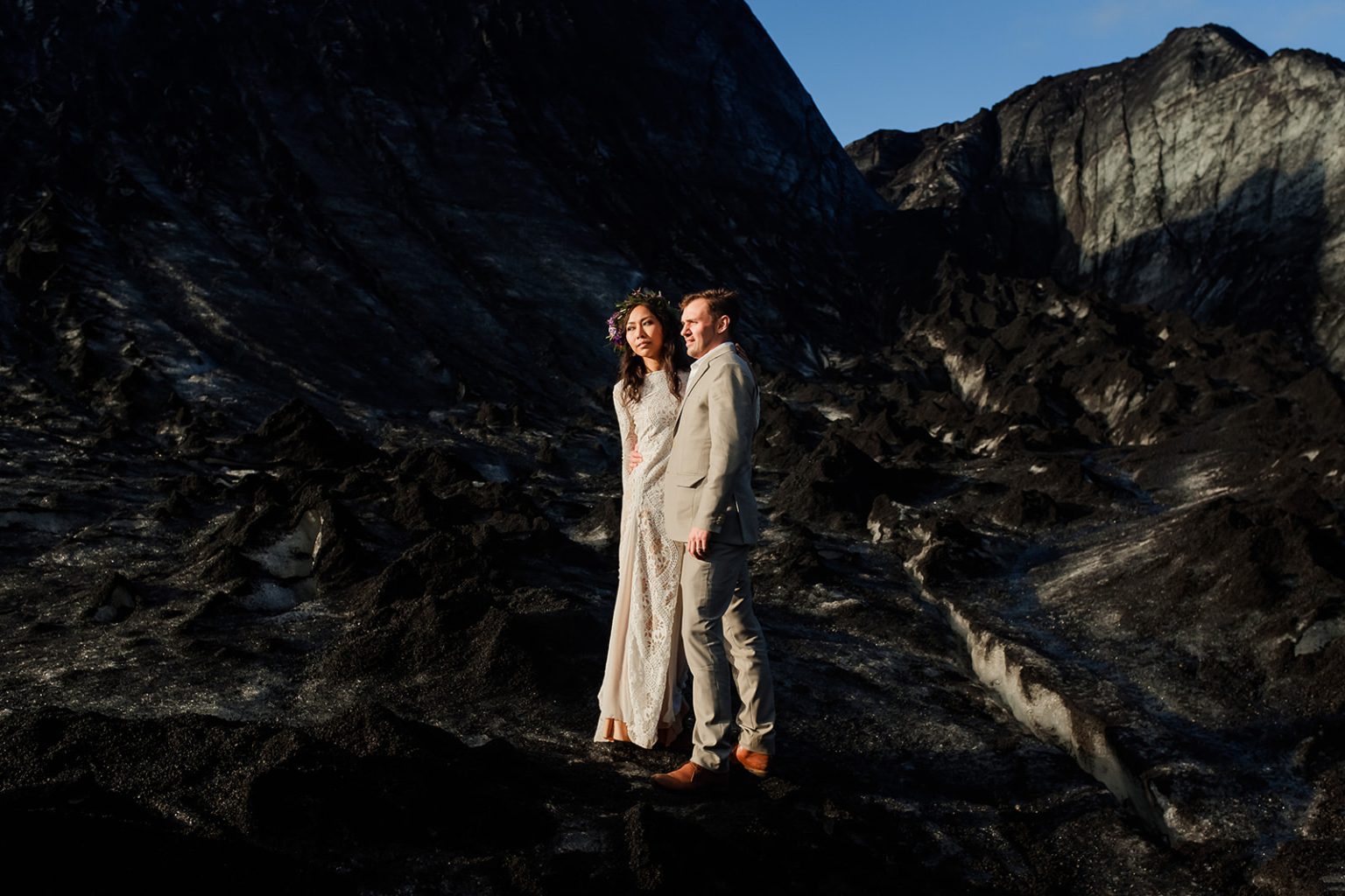 Bride and groom standing together on Solheimajokull glacier, South Iceland elopement