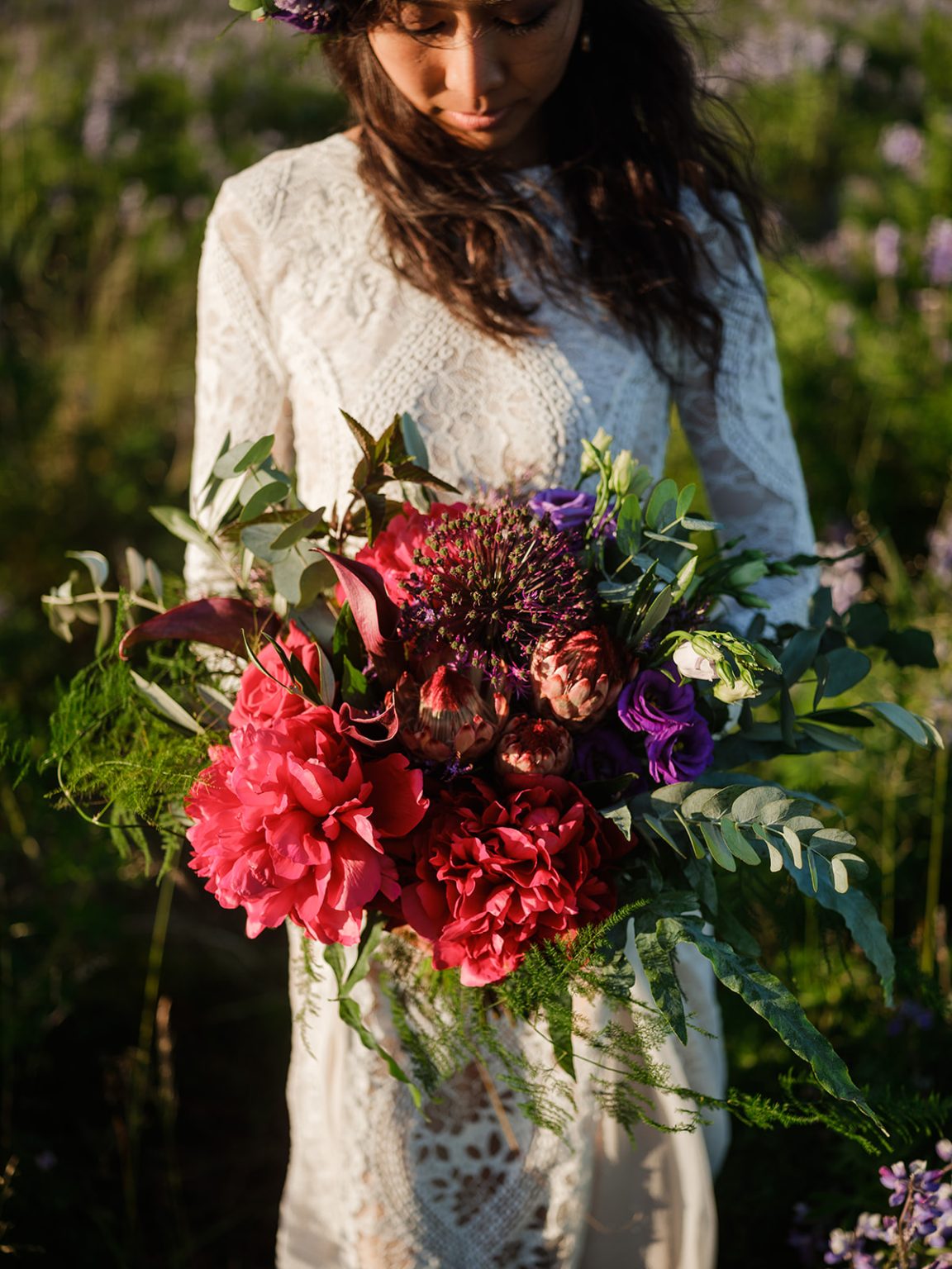 Bride with her bouquet in the evening light among the lupines, South Iceland elopement