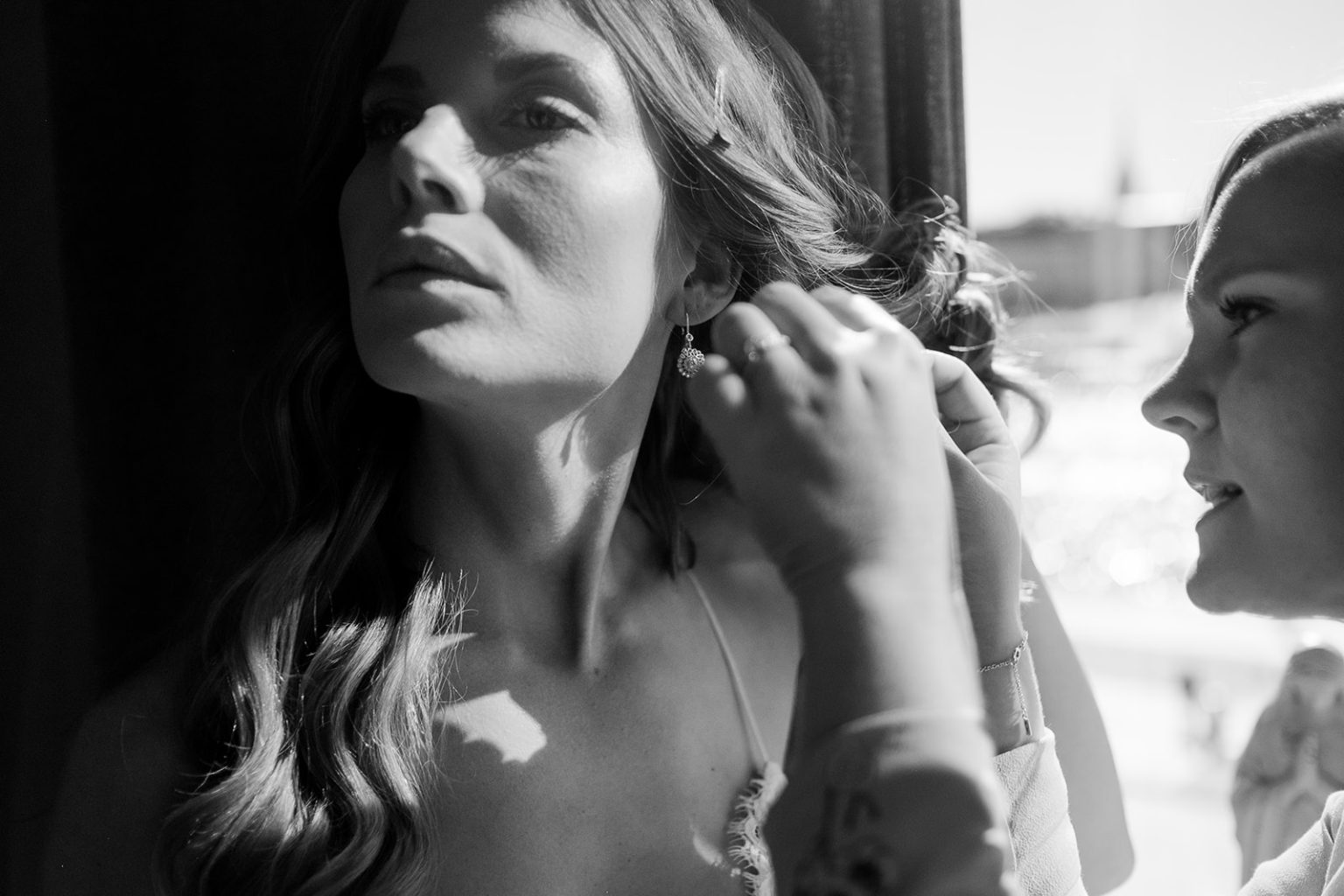 The bride putting on her earrings before the ceremony