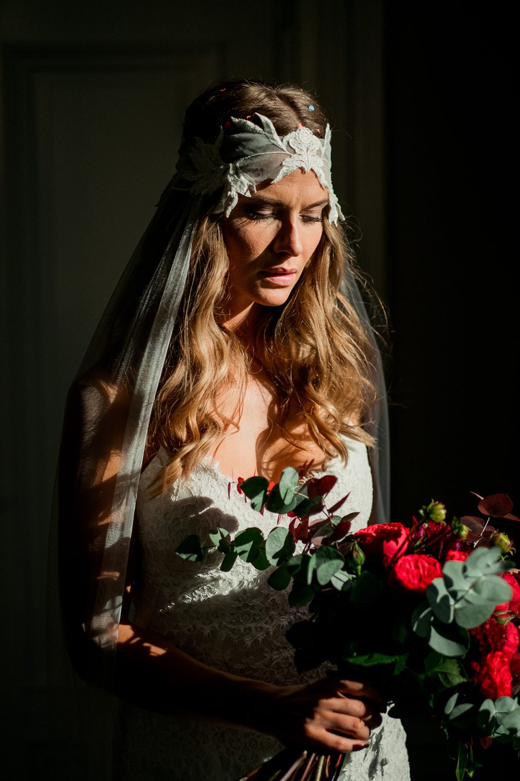 Bride with red roses in the window light at the Lydmar
