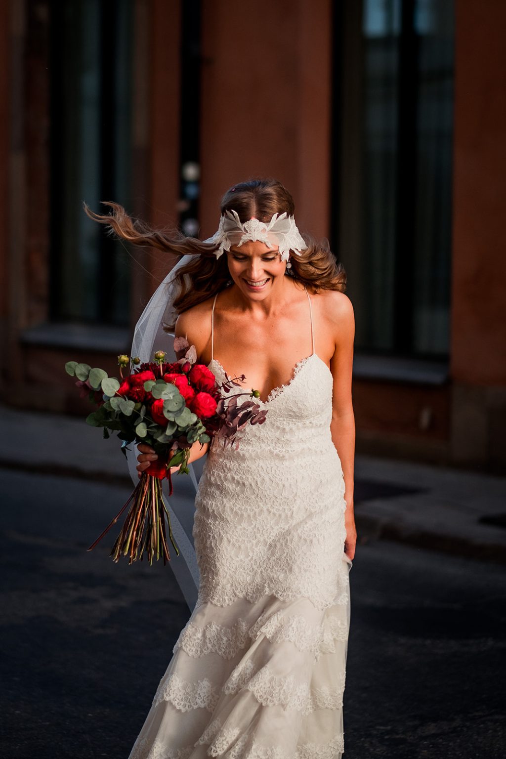 The bride with her red bouquet out in the city