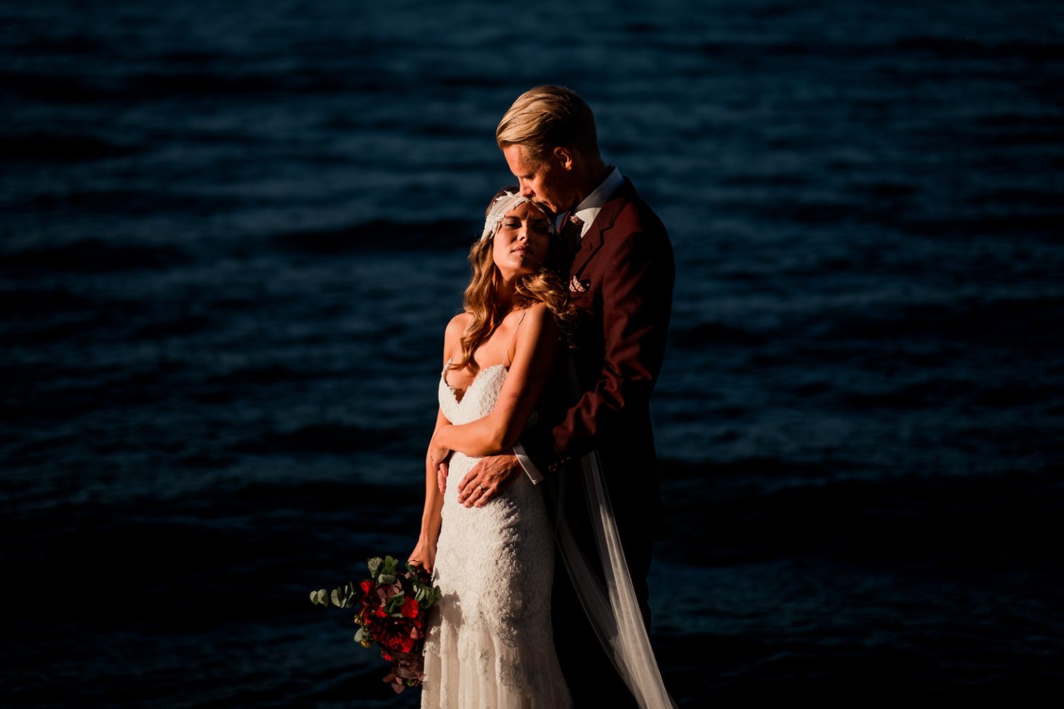 Bride and groom by the water at dusk in Stockholm