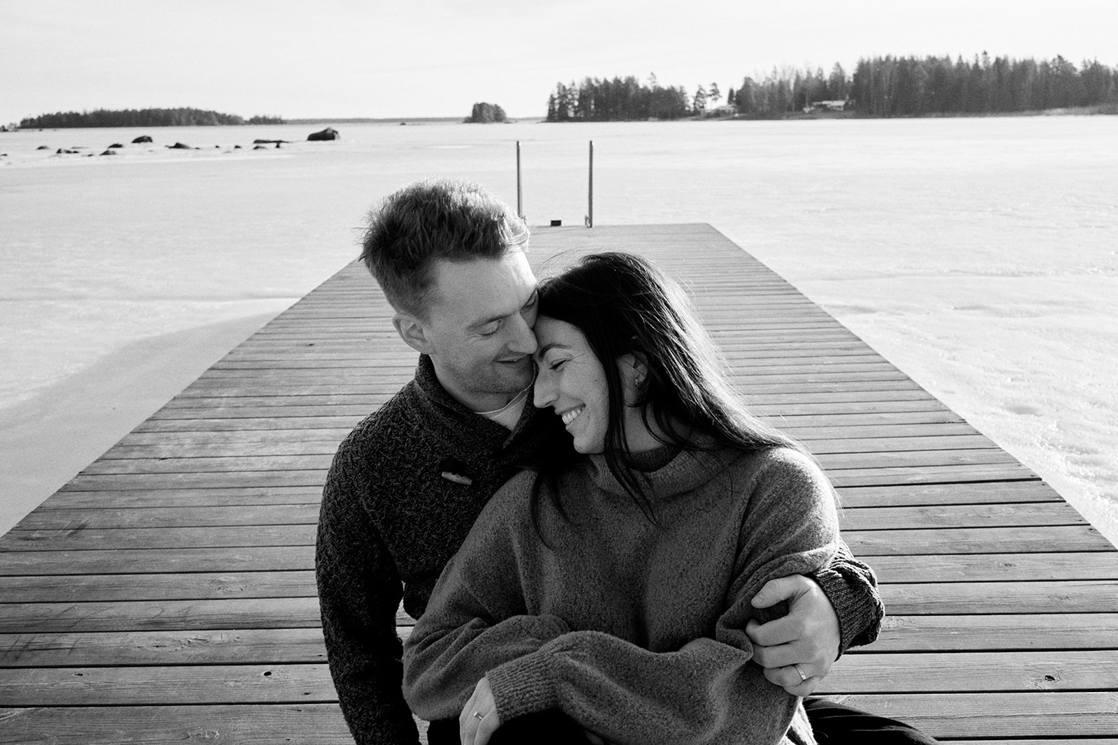 Couple on the wooden dock at Hop Farm Beach on the Baltic Sea, Söderhamn Sweden - Nordica Photography