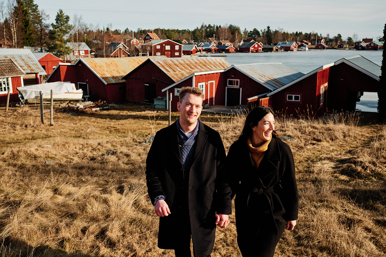 Couple by the red cottages on the Baltic shore near the Hop Farm Beach cabin, Söderhamn - Nordica Photography