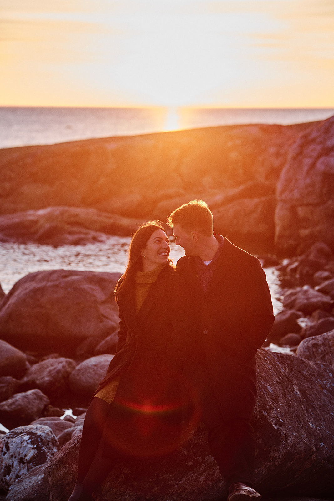 Engaged couple backlit at golden hour on the Baltic coast, Söderhamn - Nordica Photography