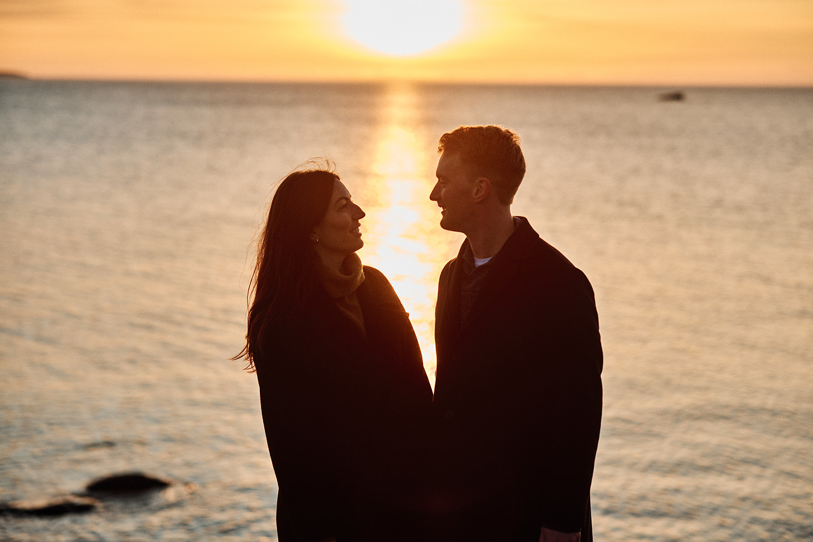 Couple silhouetted against the low sun on the Baltic, Söderhamn Sweden - Nordica Photography