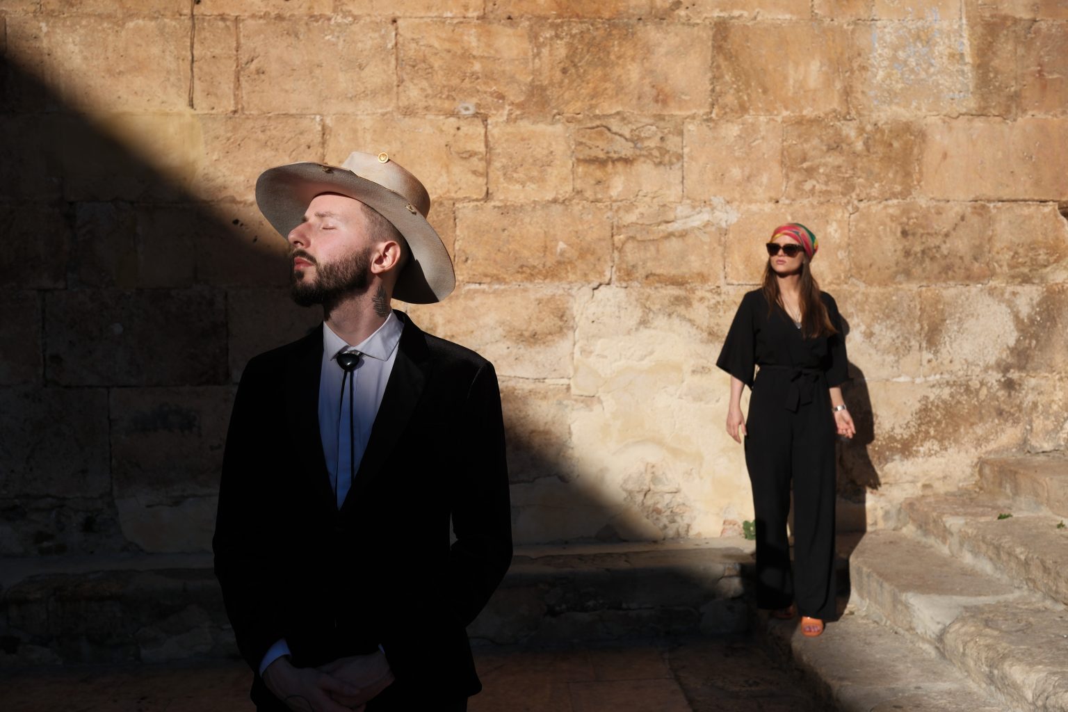 The couple against warm stone in the Valencian hills