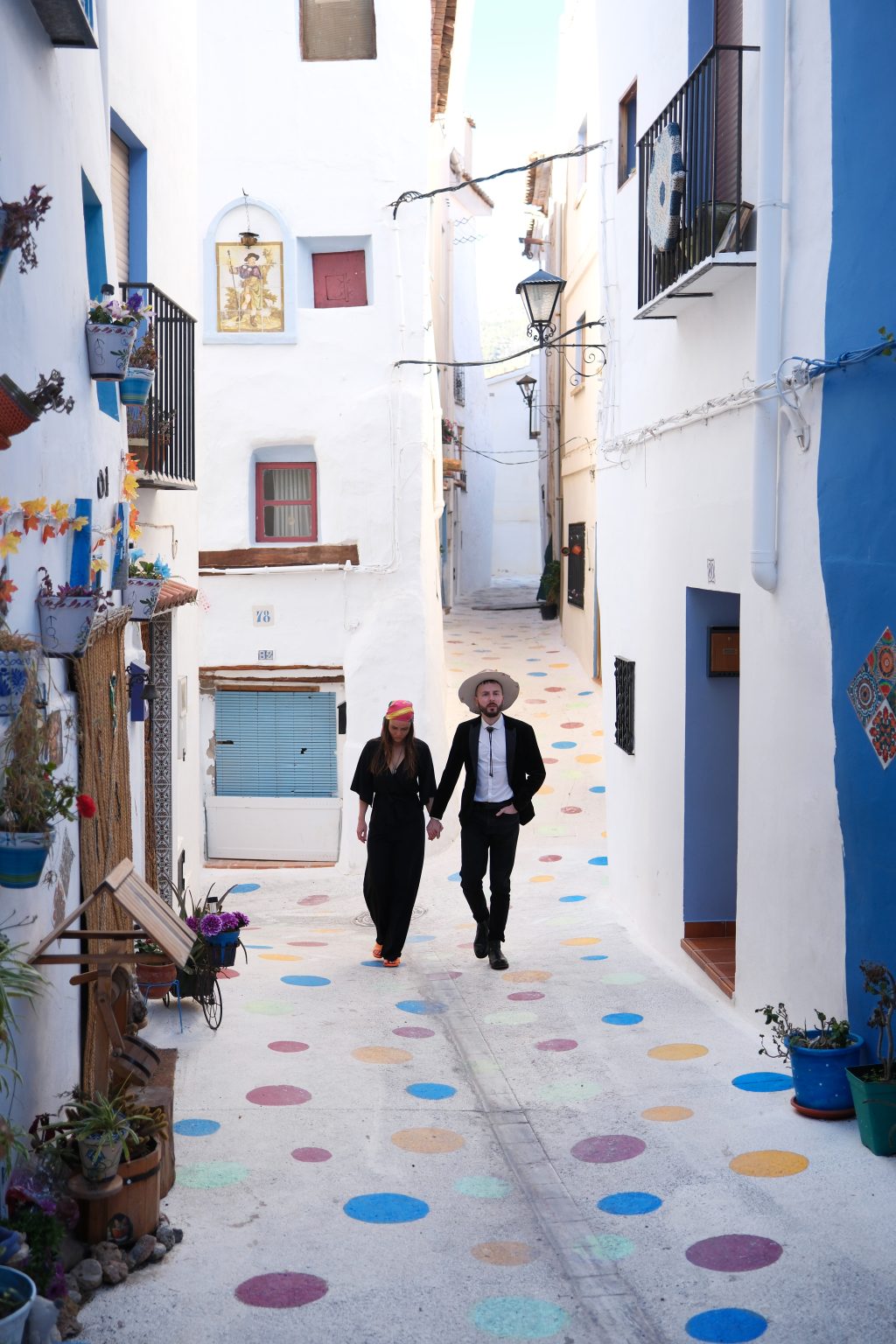 Couple in a white lane with painted cobbles in Chelva, Valencia
