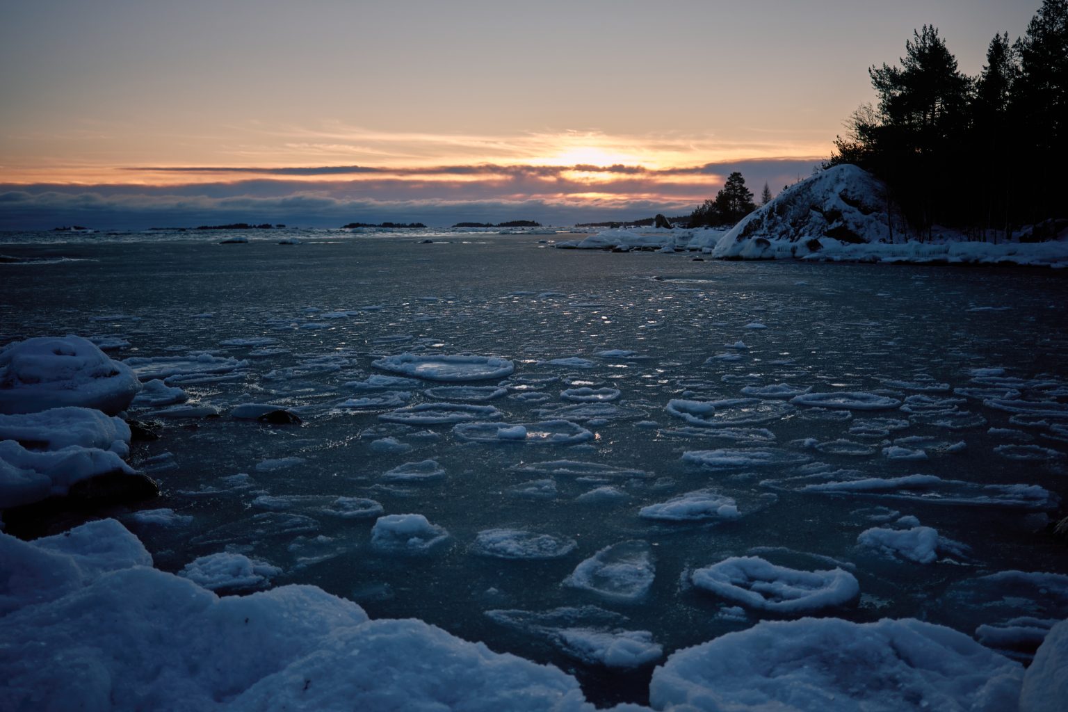 Open water in the sea ice at sunset, a Swedish winter