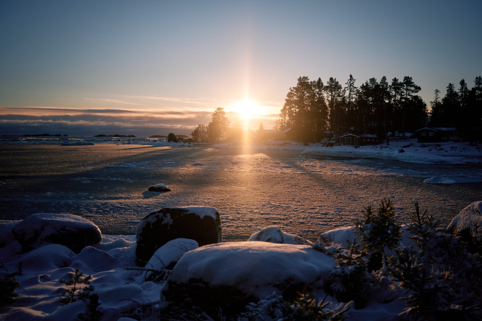 The winter sun breaking over the frozen shore, elope in Sweden