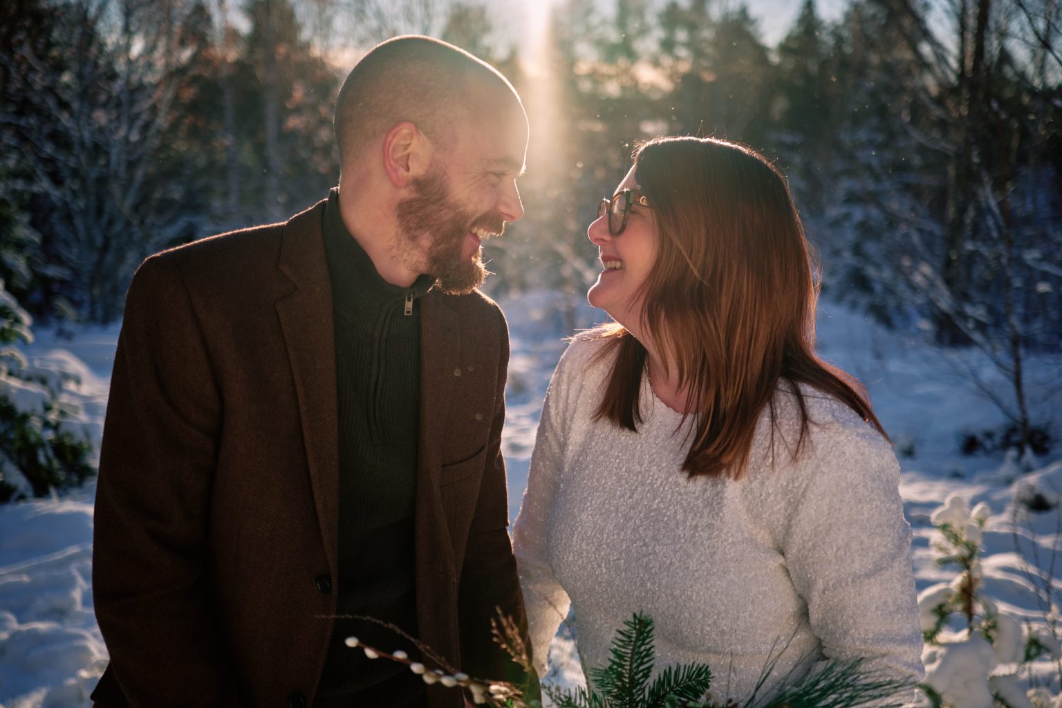 Faces together in the flare of winter sun, a Swedish elopement