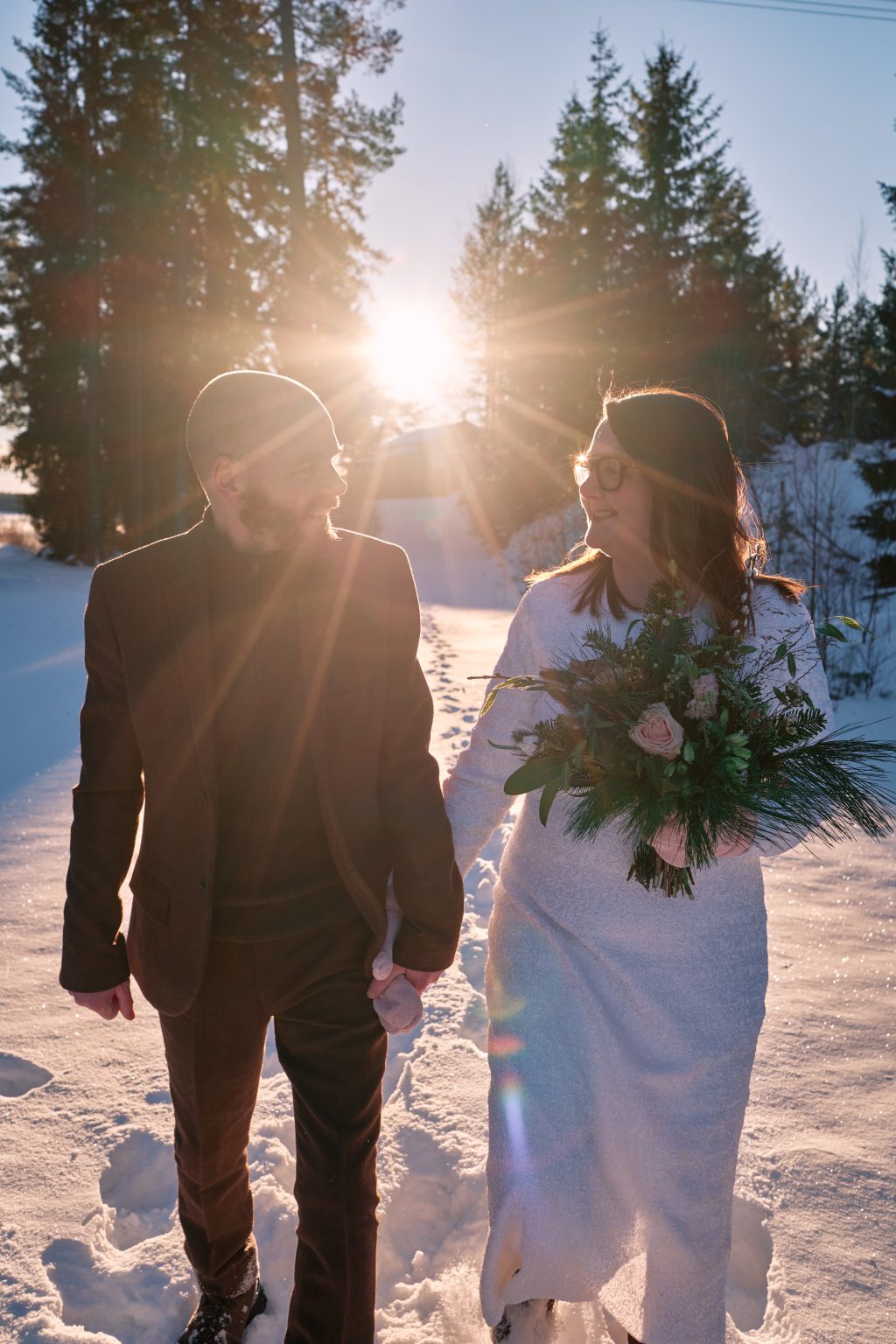 The winter sun between them in the reeds, a Nordic winter elopement