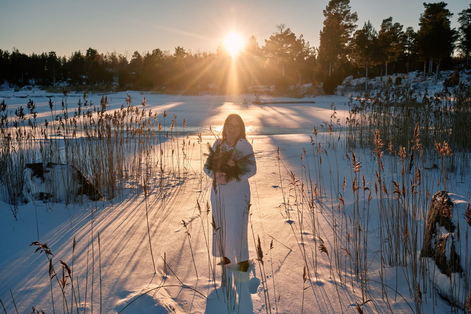 Walking into the winter sun through the reeds, Sweden