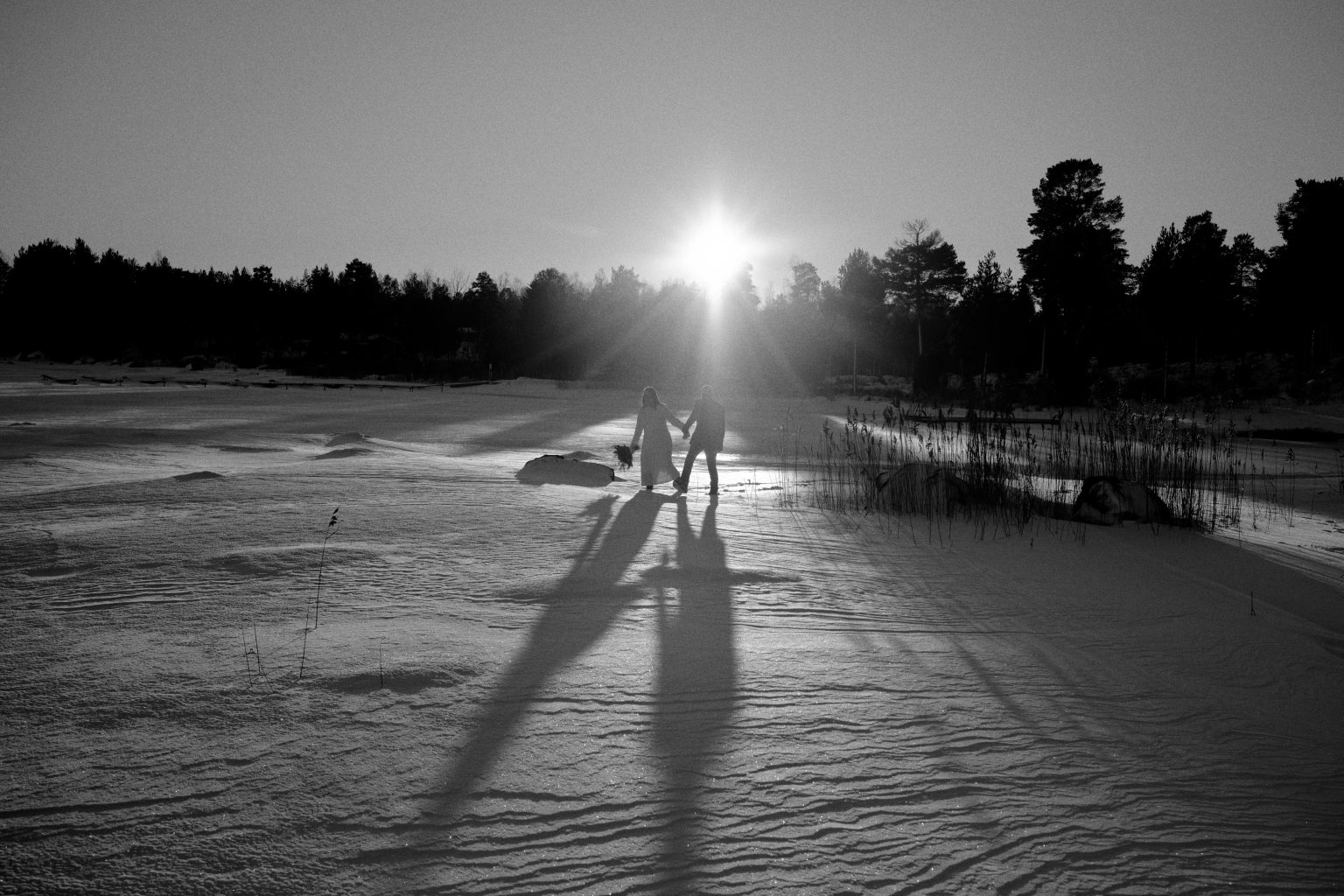 Two figures on the frozen sea in black and white, a Swedish winter