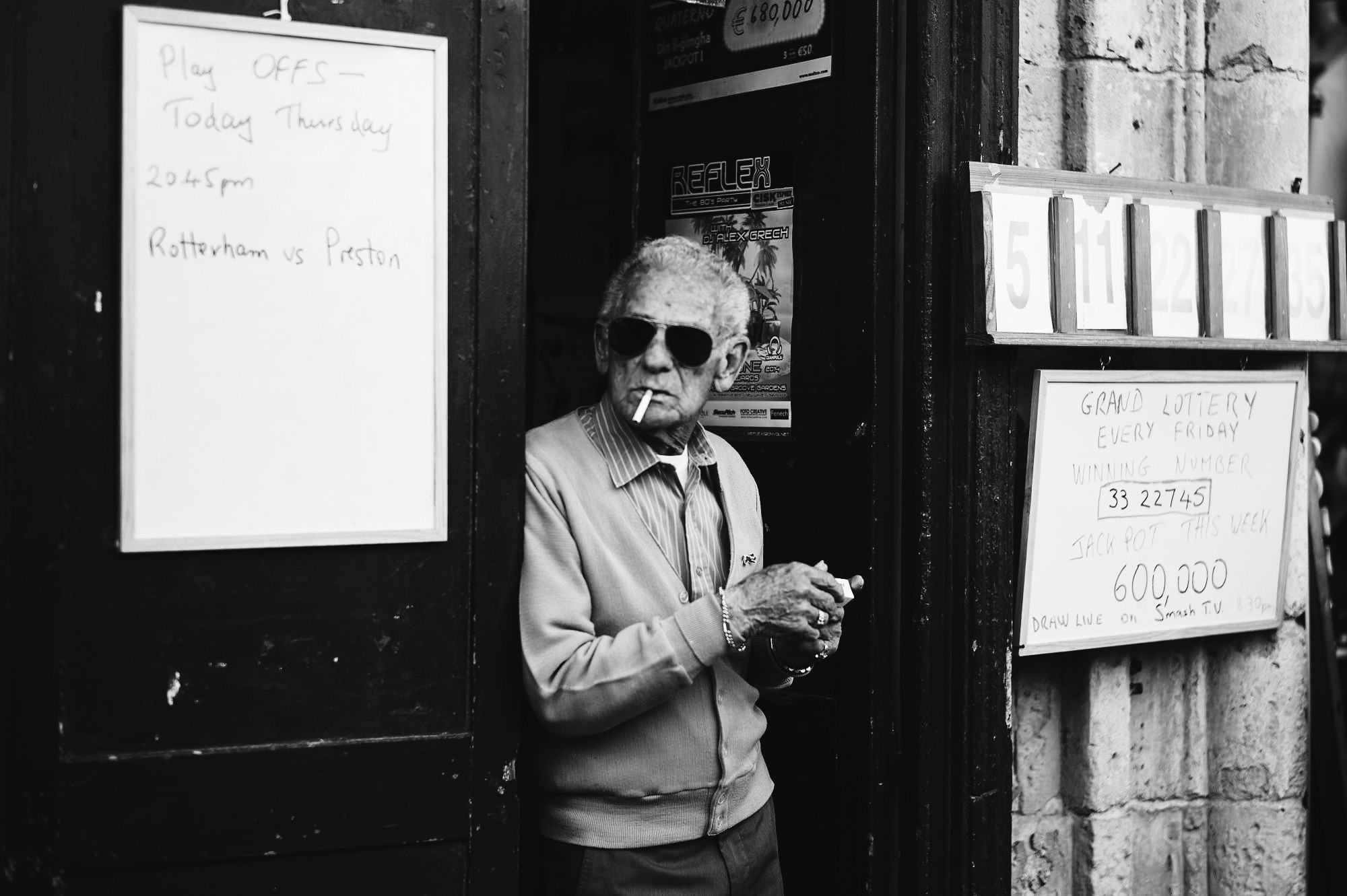 A man smoking in a doorway in Malta, black and white street photograph