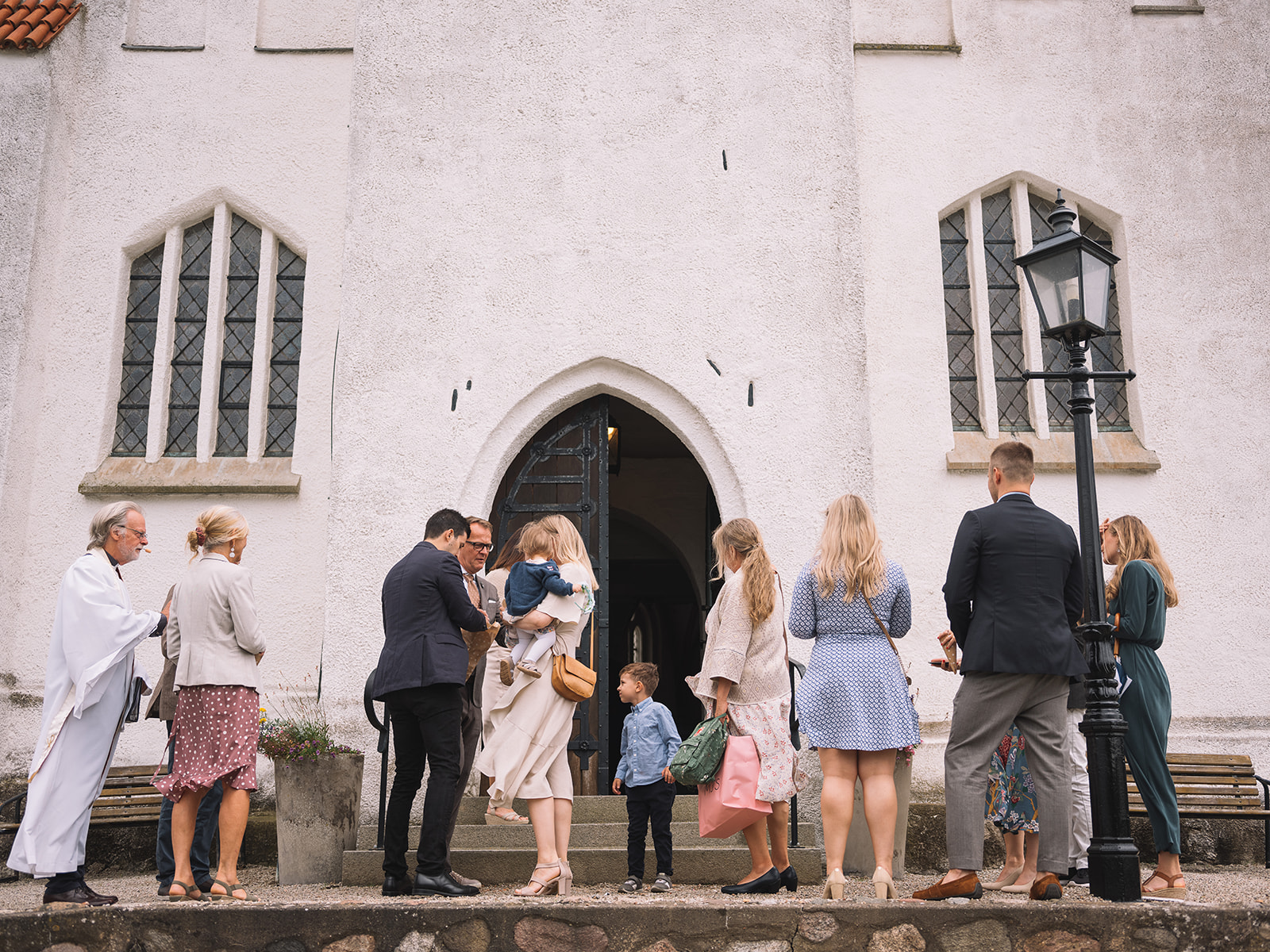 The whole wedding party on the steps of Fru Alstads kyrka