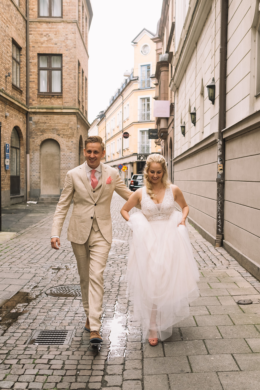 Bride and groom walking through central Malmö