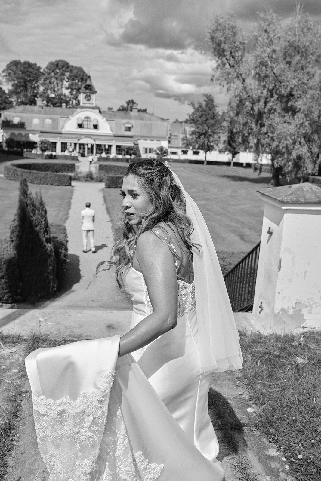 The bride walking by the water before the first look, black and white