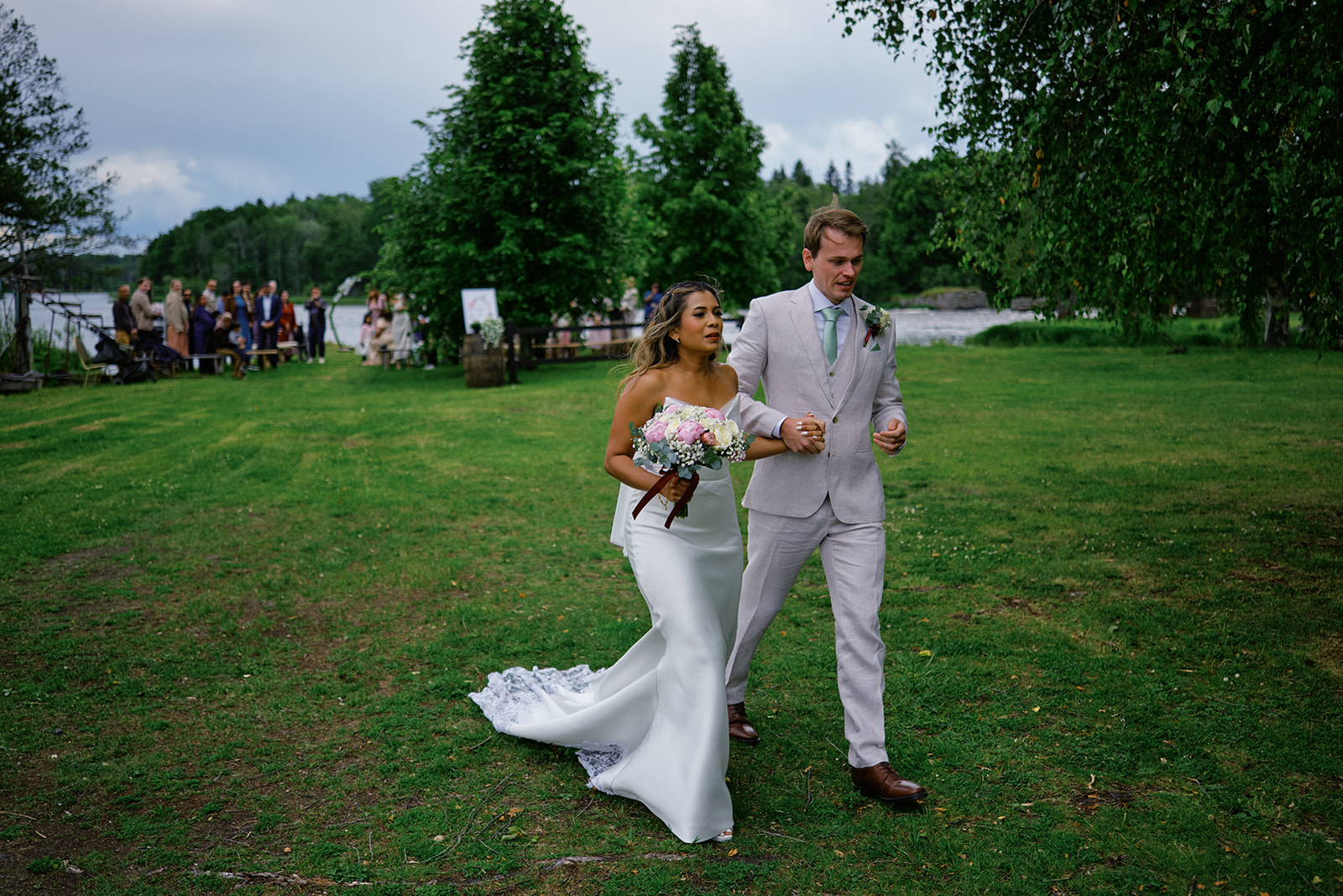 Bride and groom on the lawn after the ceremony, the river behind