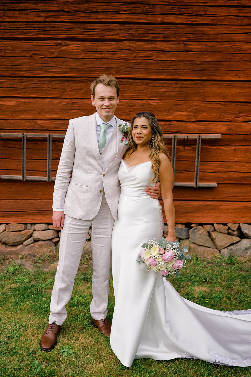 Wedding portrait against a falu red barn at Gysinge bruk
