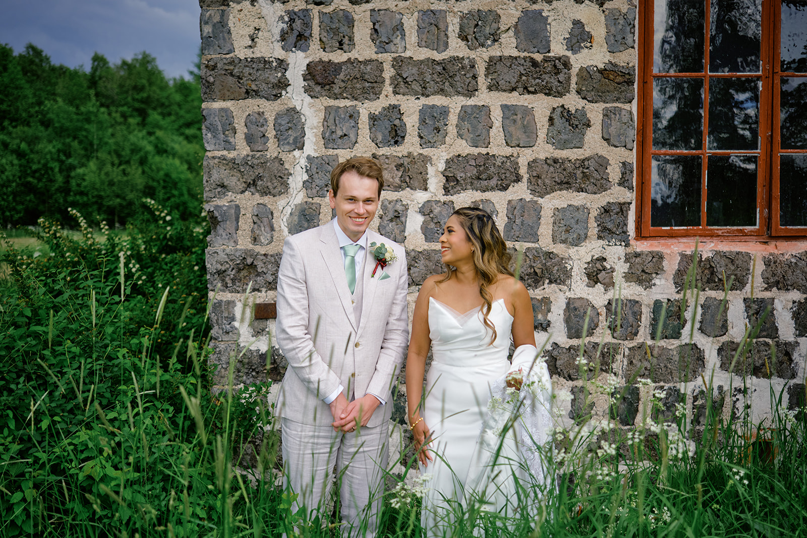 Gysinge Herrg&aring;rd br&ouml;llop, the couple against an old stone wall of the ironworks