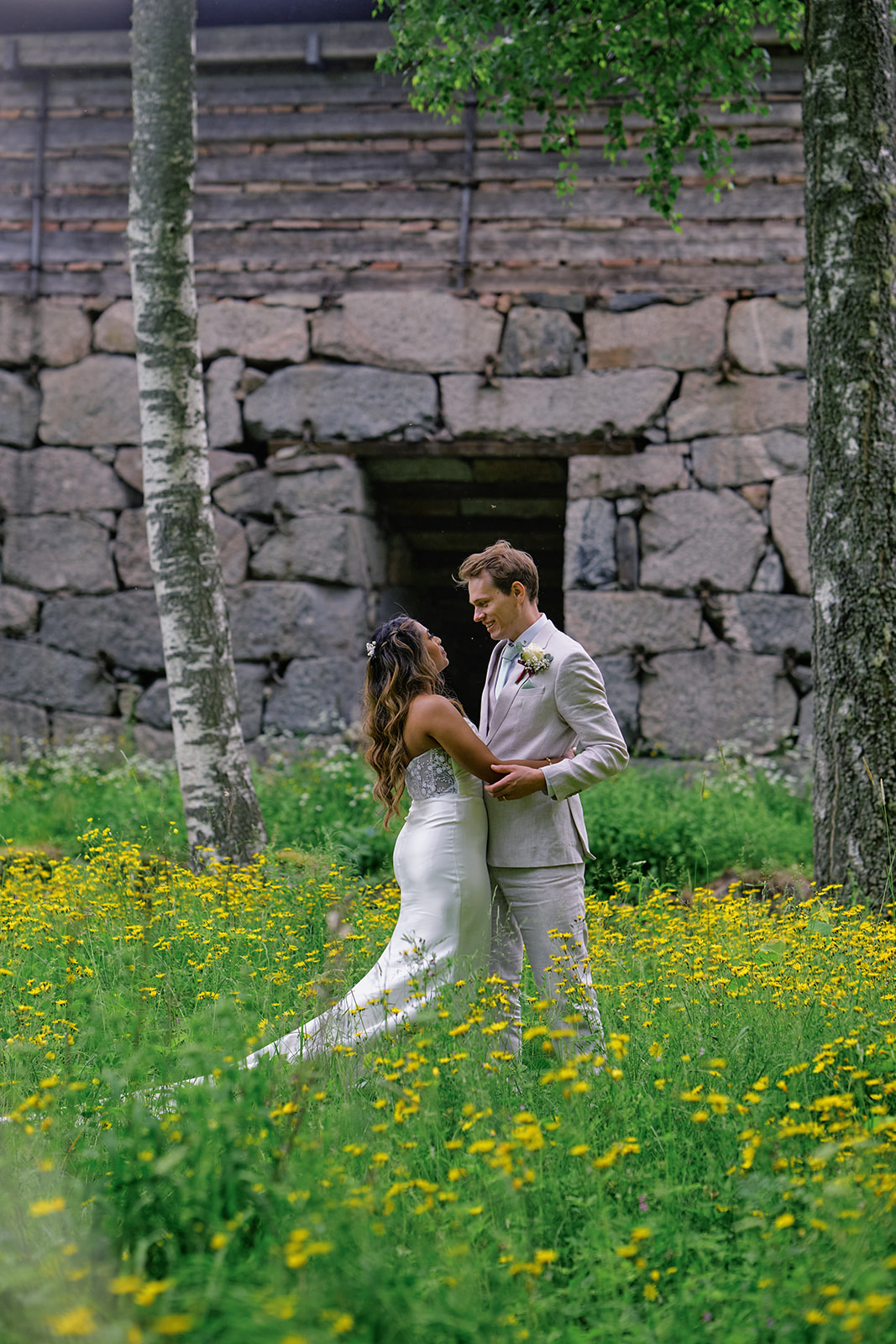 The couple in a buttercup meadow beside a stone ruin at Gysinge