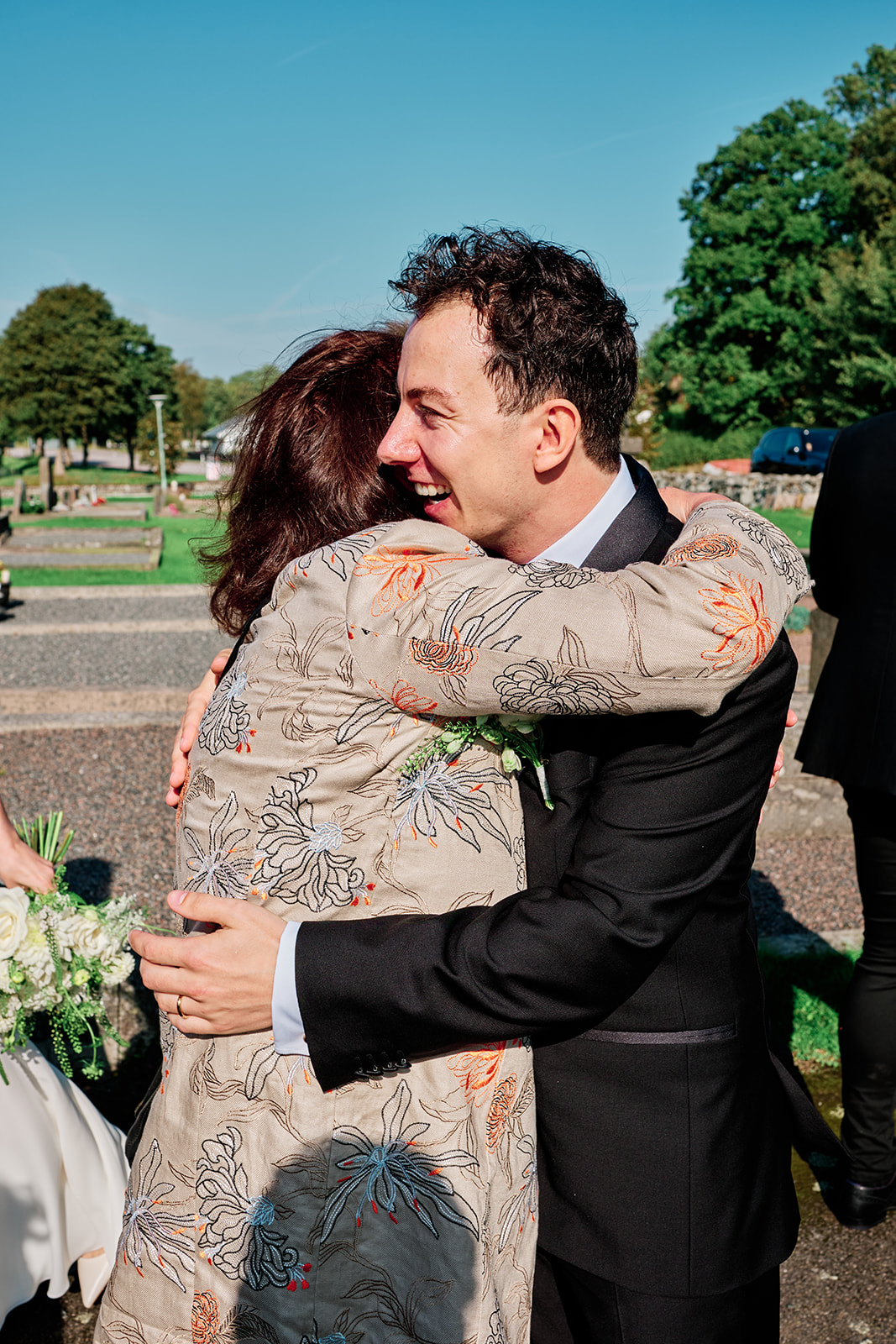 A guest hugging the groom outside the church