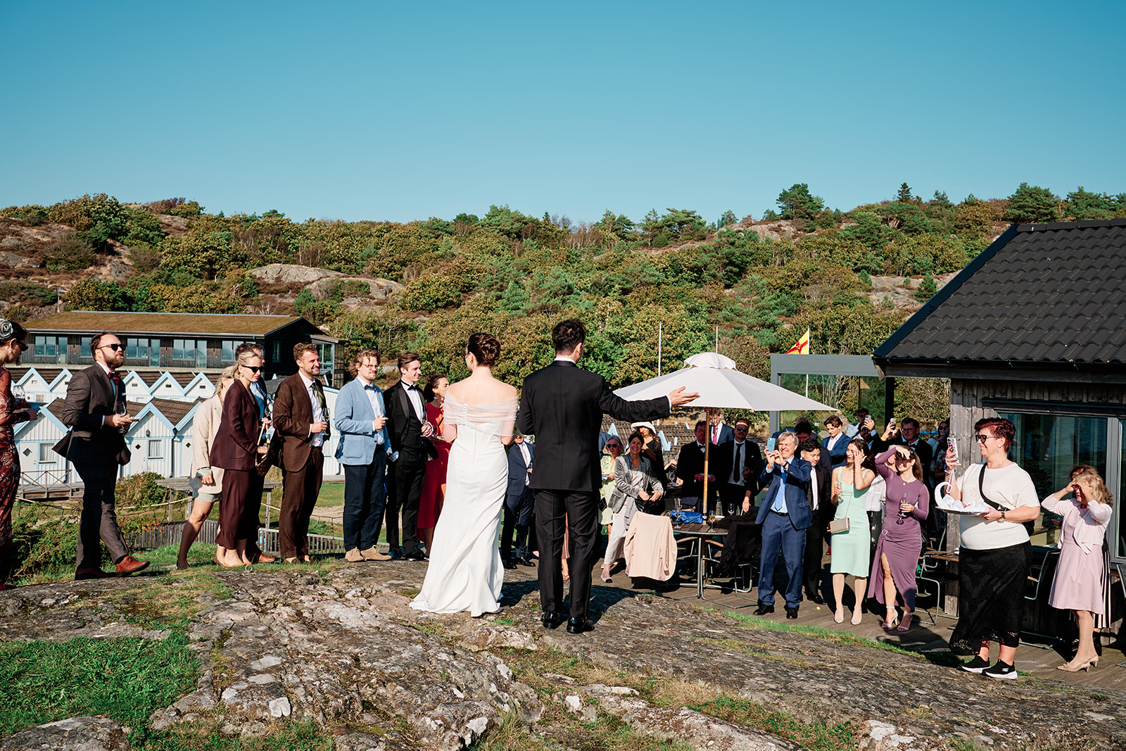 The wedding party spread along the granite at Hov&aring;s Kallbadhus